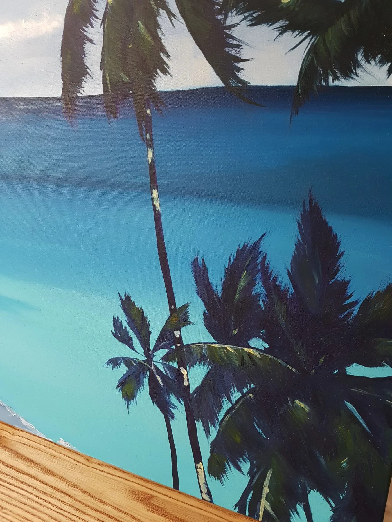 Close-up of turquoise sea and palm silhouettes in oil